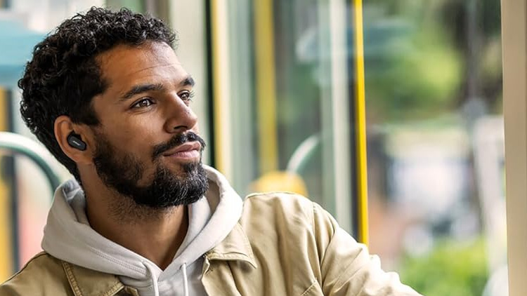 man on bus with Bose earbuds in his ears